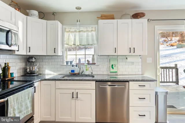 a kitchen with stainless steel appliances granite countertop a sink a stove and cabinets