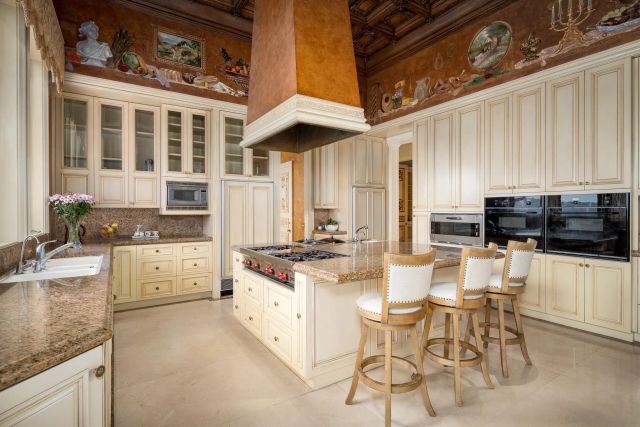 a kitchen with a stove a sink and white cabinets