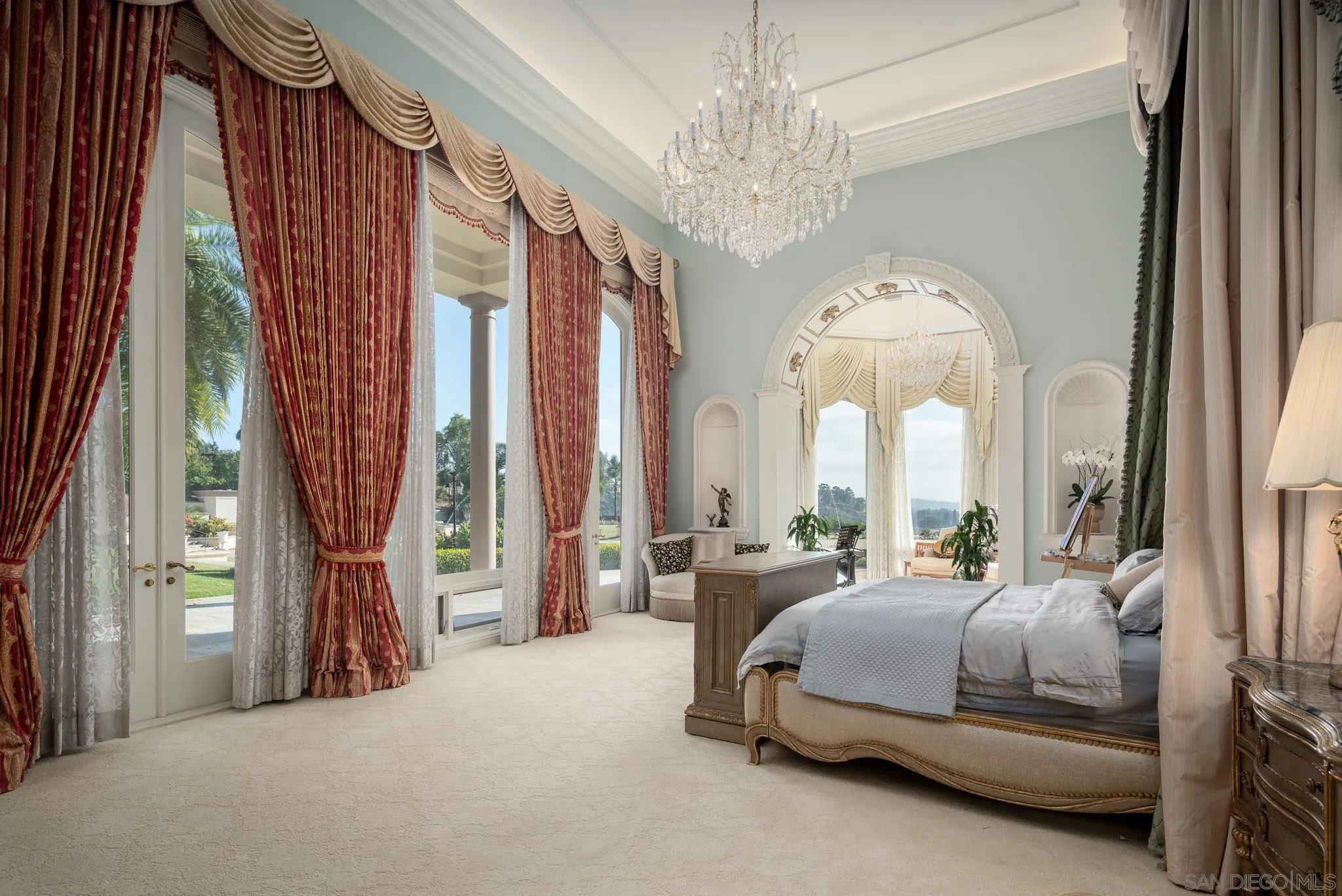 6883 Alydar Corte Del Mar, CA 92014 - Photo 29 of 48 a bedroom with a large bed and a chandelier next to a window