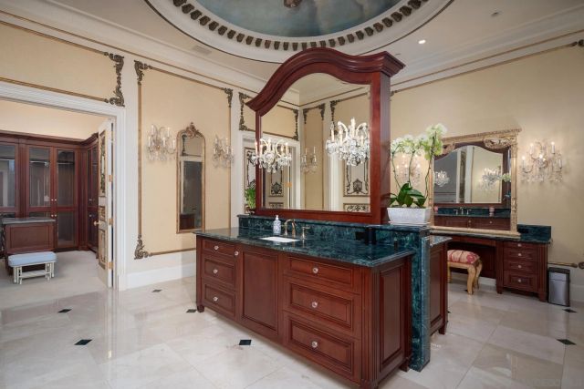 a bedroom with a large bed and a chandelier