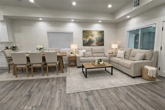 a living room with furniture a wooden floor and a window