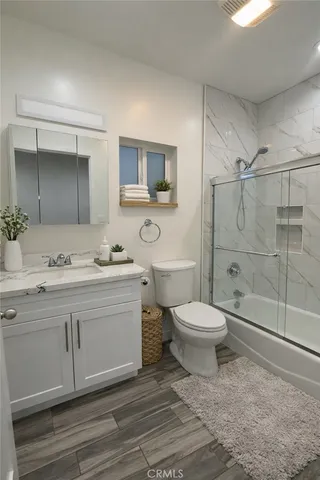 a bathroom with a toilet a sink a mirror and vanity