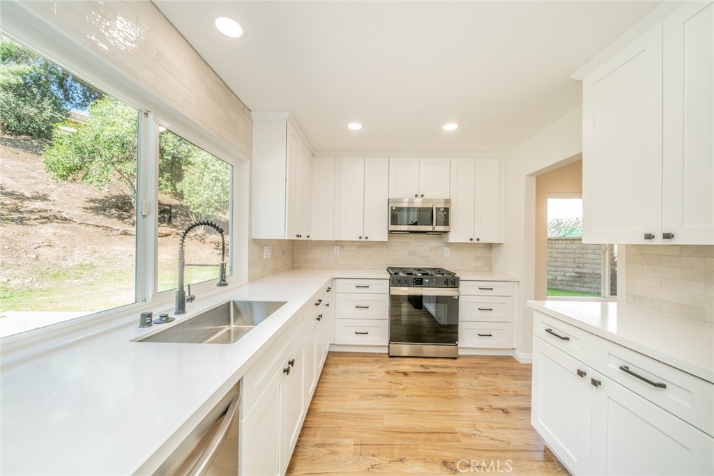 3 Wild W Circle Phillips Ranch, CA 91766 - Photo 12 of 65 a large kitchen with stainless steel appliances granite countertop a stove a sink and a granite counter tops with a large window