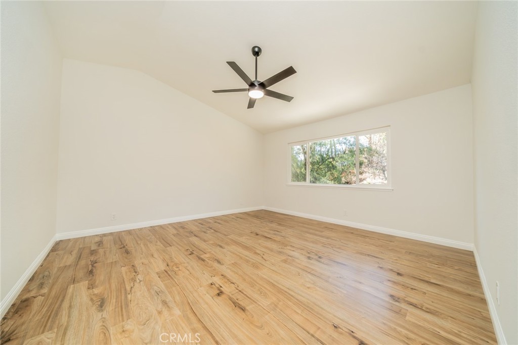 3 Wild W Circle Phillips Ranch, CA 91766 - Photo 24 of 65 an empty room with wooden floor ceiling fan and windows