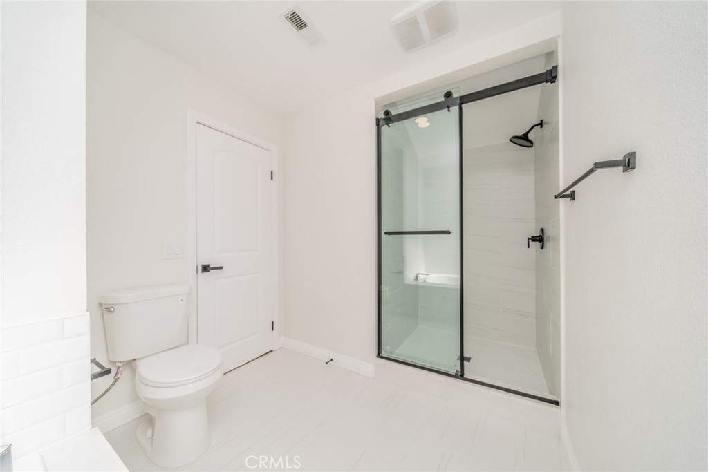 3 Wild W Circle Phillips Ranch, CA 91766 - Photo 31 of 65 a white toilet sitting next to a bathroom sink