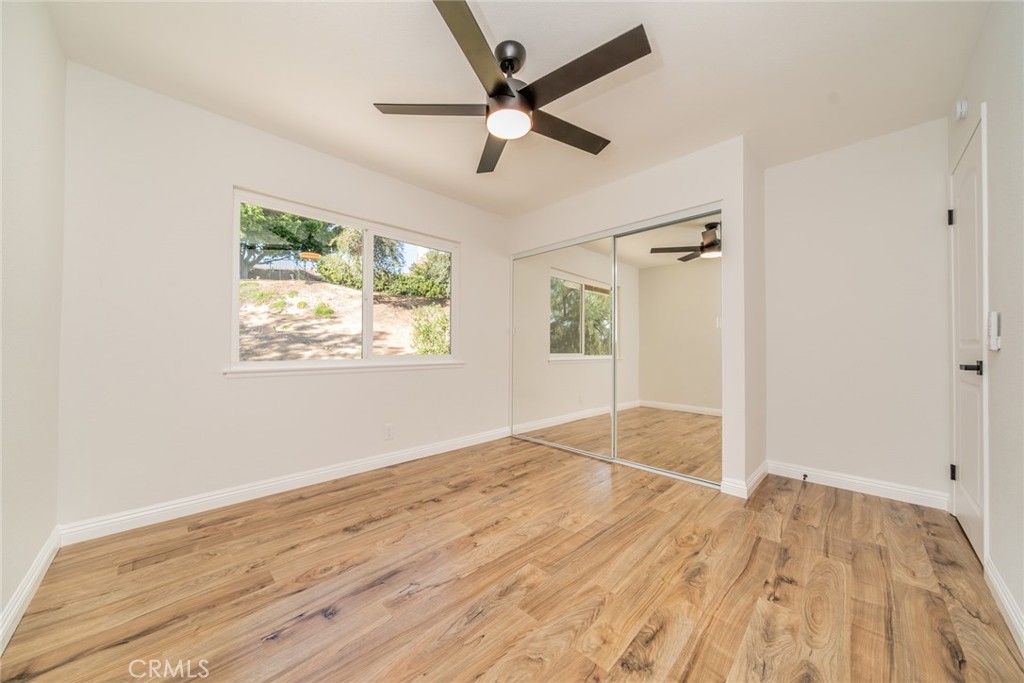 3 Wild W Circle Phillips Ranch, CA 91766 - Photo 37 of 65 an empty room with wooden floor ceiling fan and windows