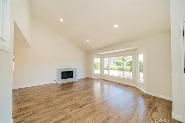 an empty room with wooden floor and a window