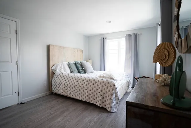a bedroom with a bed and flat tv screen on the dresser
