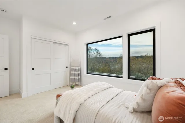 a bedroom with a large bed and a large window