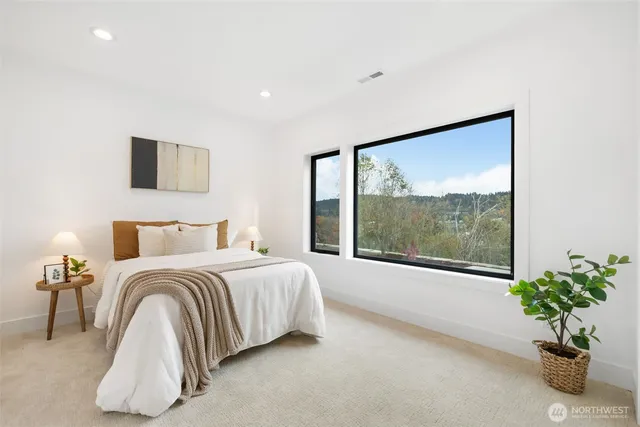 a bedroom with a balcony a bed and a large window