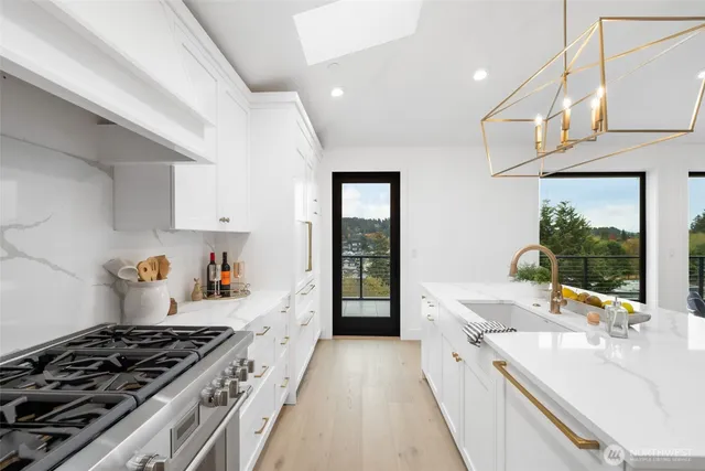 a large kitchen with stainless steel appliances kitchen island granite countertop a lot of counter space and wooden floors