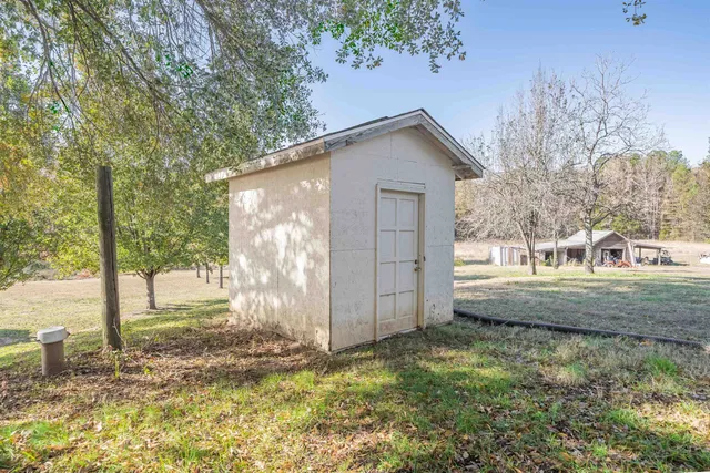 a view of a house with backyard and tree