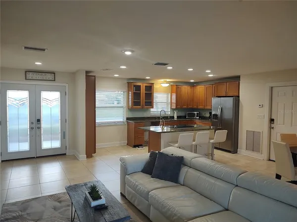 a living room with furniture and a view of kitchen