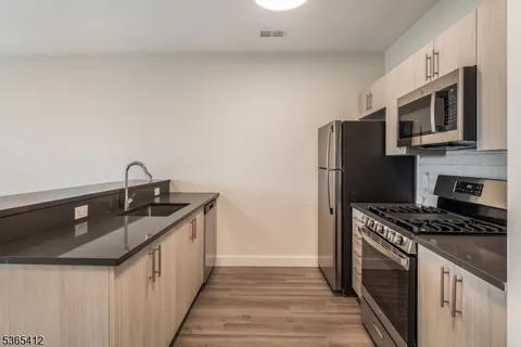 a kitchen with stainless steel appliances a sink stove and refrigerator