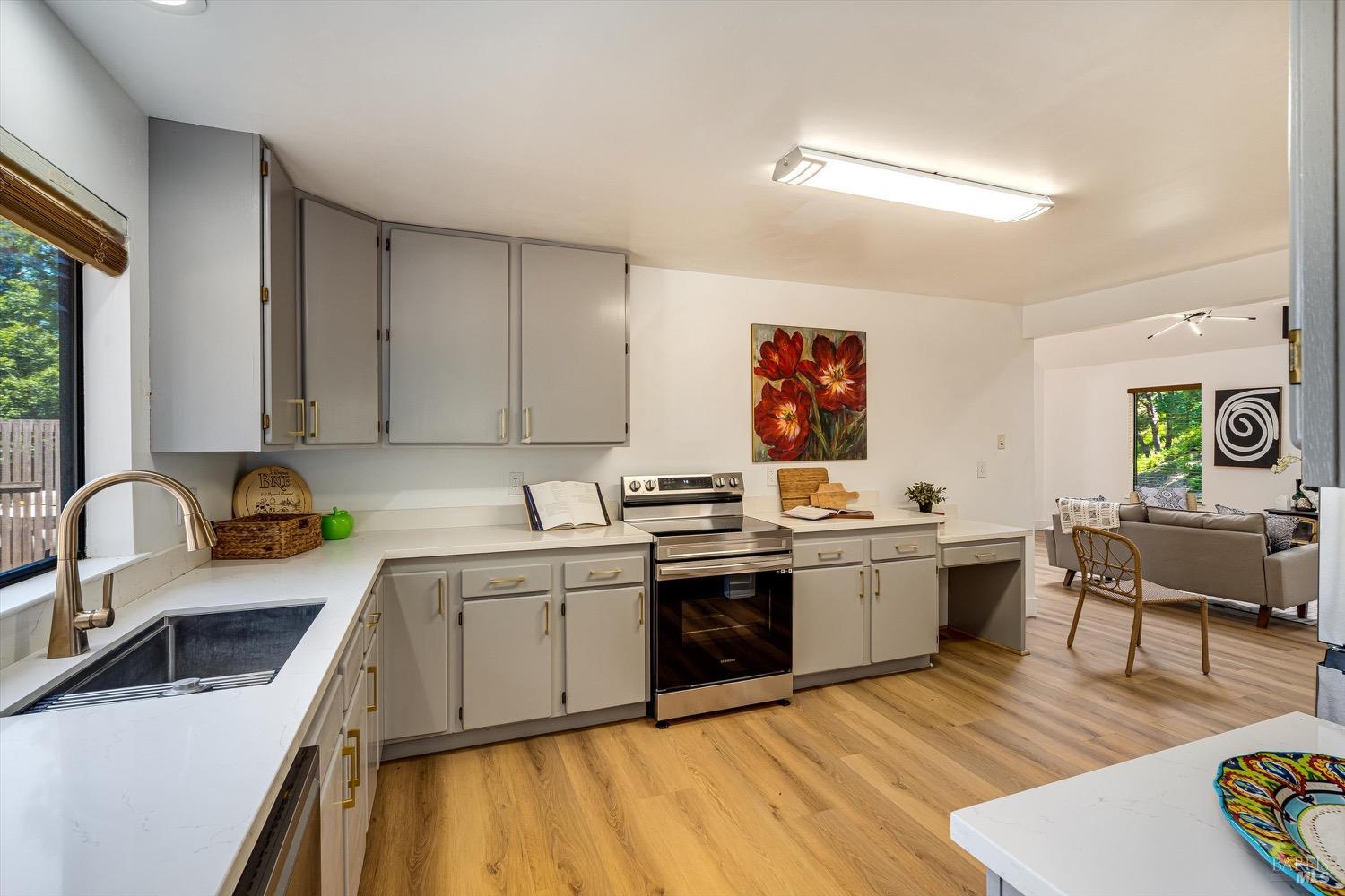 168 Ridgecrest Drive Napa, CA 94558 - Photo 16 of 39 a kitchen with stainless steel appliances granite countertop a stove top oven a sink dishwasher and white cabinets with wooden floor