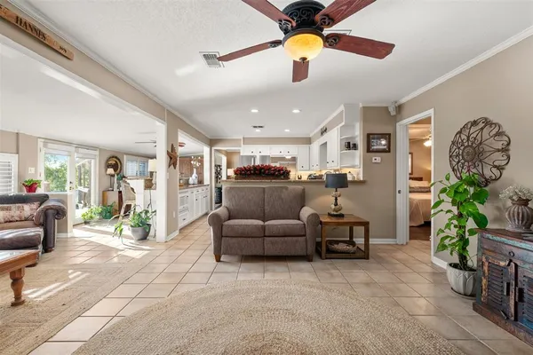 a living room with furniture a ceiling fan and a window