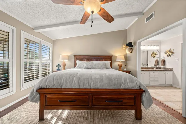 a bedroom with a large bed and a chandelier