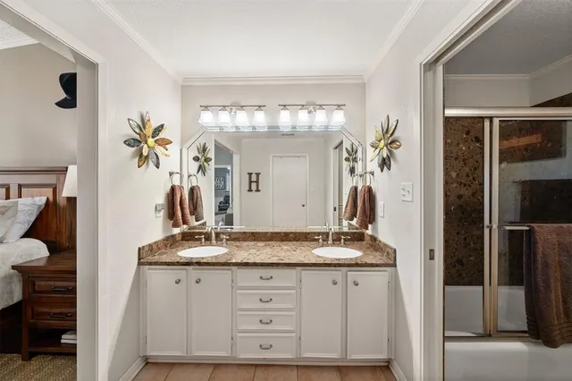 a bathroom with a granite countertop sink a mirror and a shower