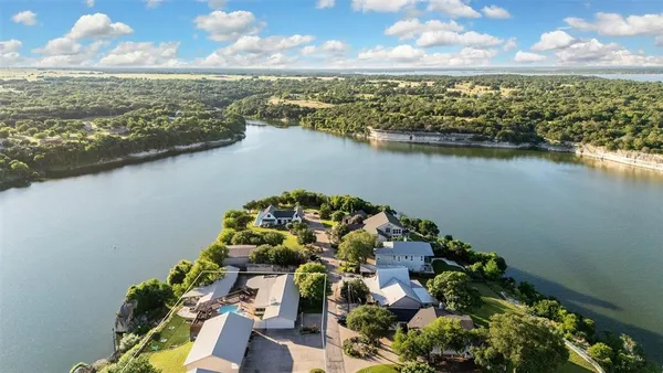 an aerial view of residential houses with outdoor space and lake view
