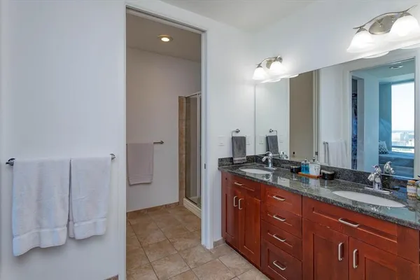 a spacious bathroom with a granite countertop sink and a mirror