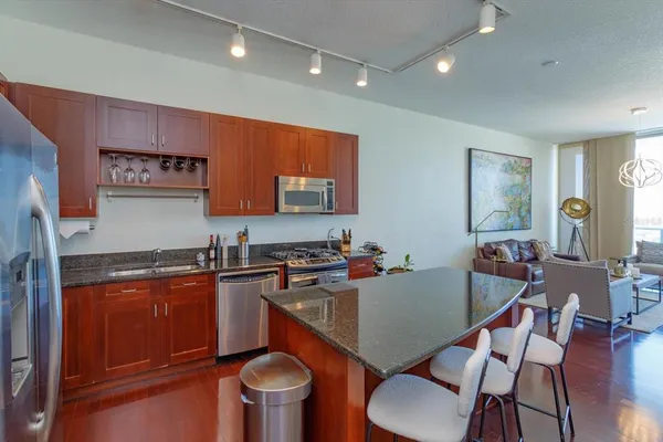 a kitchen with granite countertop a sink stove and cabinets