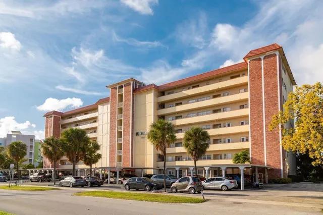 a view of a swimming pool with a lounge chair and trees in the background