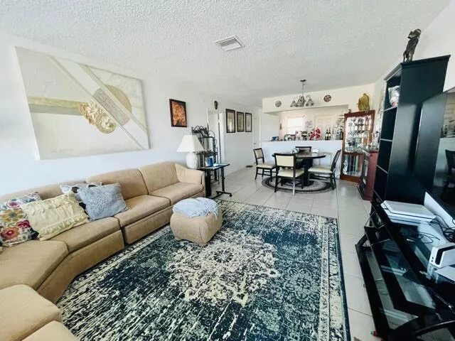 a living room with furniture a rug and a flat screen tv