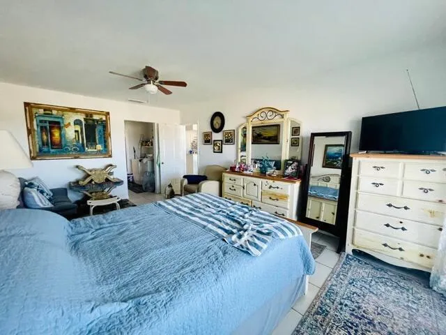 a bedroom with a bed and a flat tv screen on dresser