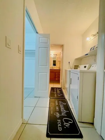 a hallway with white cabinets and wooden floor