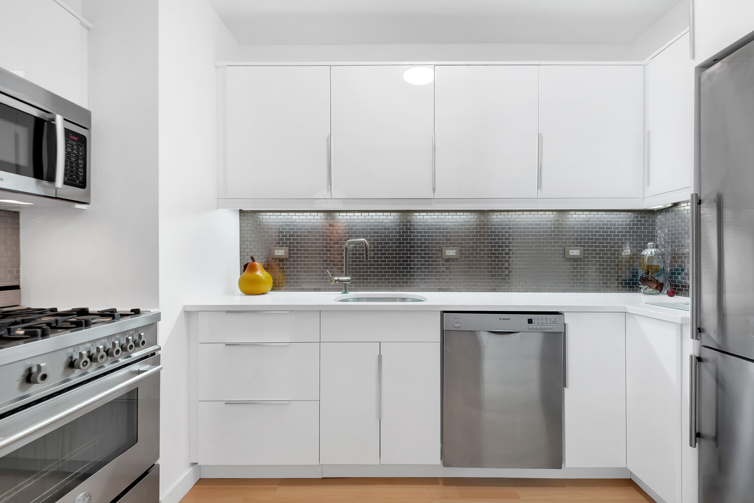 45 Sutton Place South, Unit 11J Manhattan, NY 10022 - Photo 3 of 19 a kitchen with white cabinets and appliances