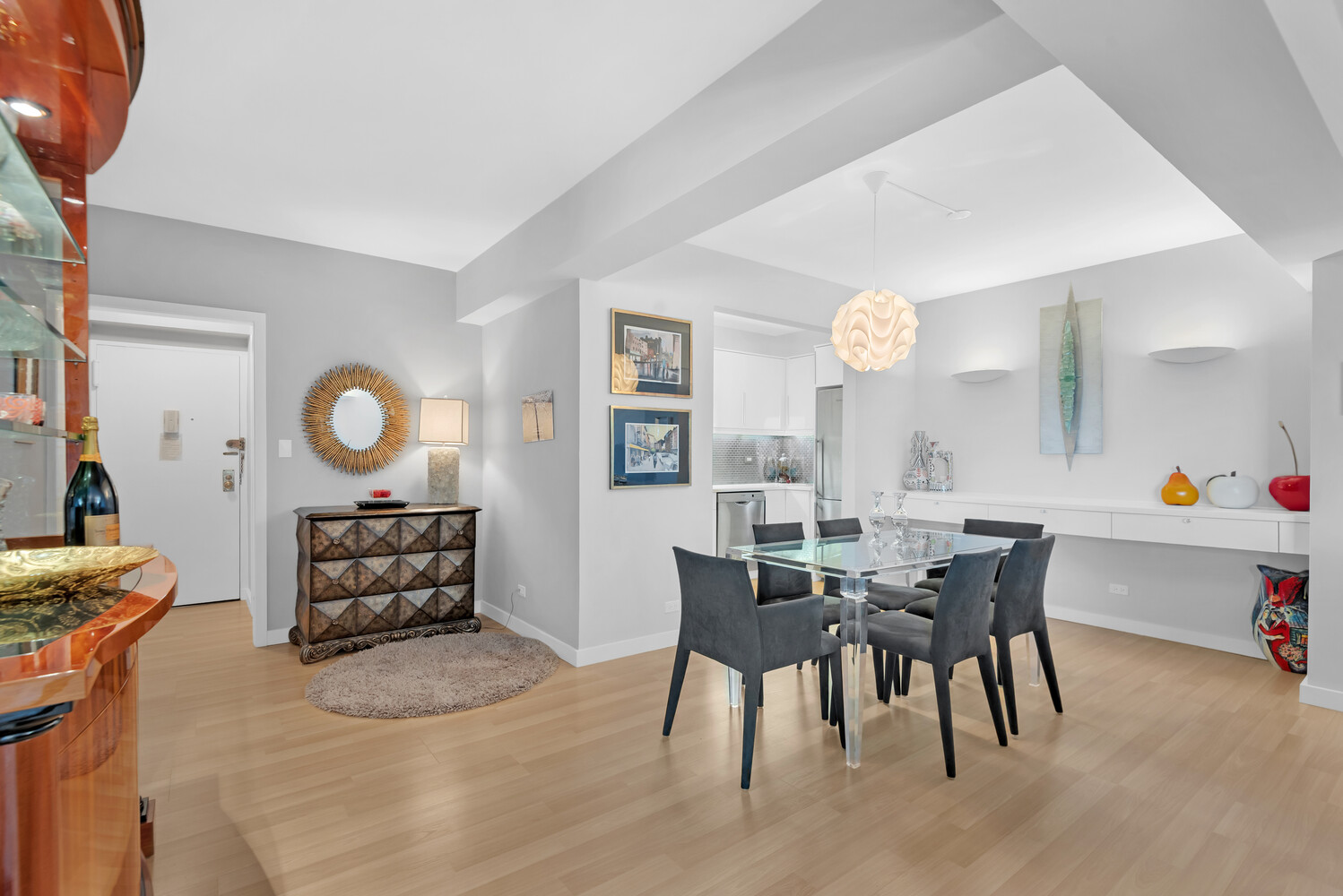 45 Sutton Place South, Unit 11J Manhattan, NY 10022 - Photo 4 of 19 a view of a dining room and livingroom with furniture wooden floor and a rug