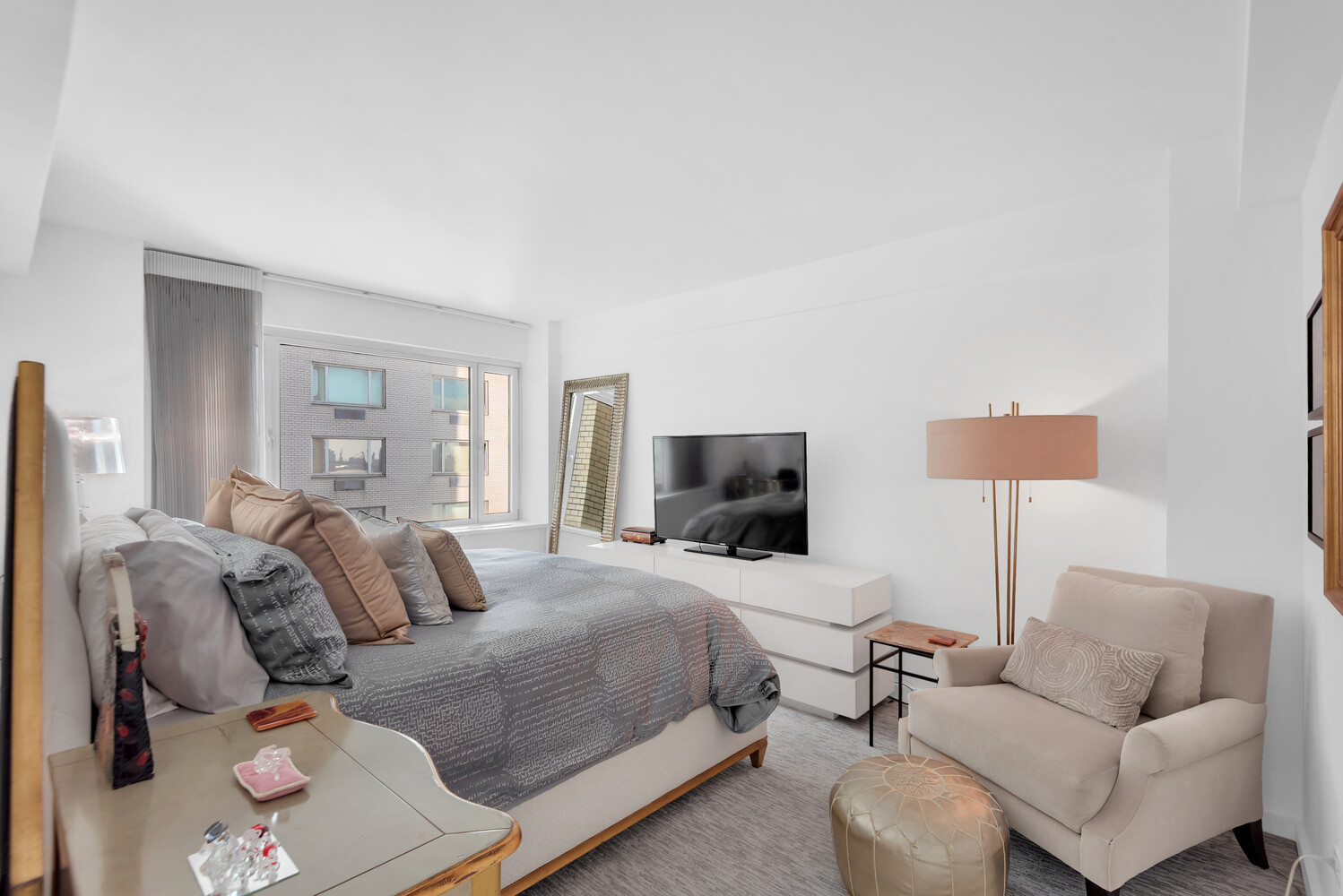 45 Sutton Place South, Unit 11J Manhattan, NY 10022 - Photo 5 of 19 a bedroom with a bed and a couch
