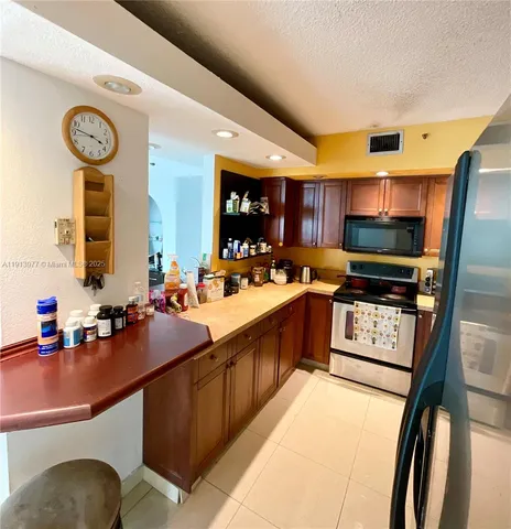 a kitchen with a table chairs and refrigerator