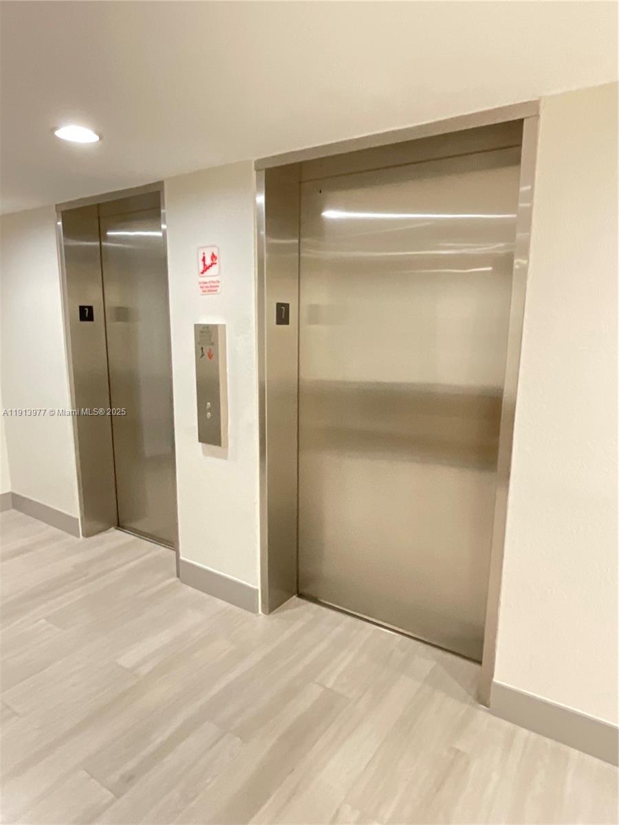 919 Hillcrest Drive, Unit 704 Hollywood, FL 33021 - Photo 7 of 43 a view of an empty room with wooden floor and a bathroom