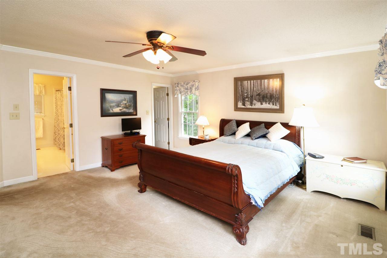 1500 Pecore Place Raleigh, NC 27615 - Photo 12 of 25 a bedroom with a bed and a chandelier