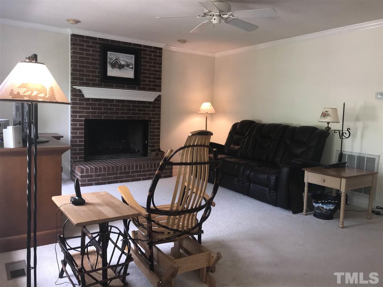 1500 Pecore Place Raleigh, NC 27615 - Photo 3 of 25 a living room with furniture a fireplace and a lamp