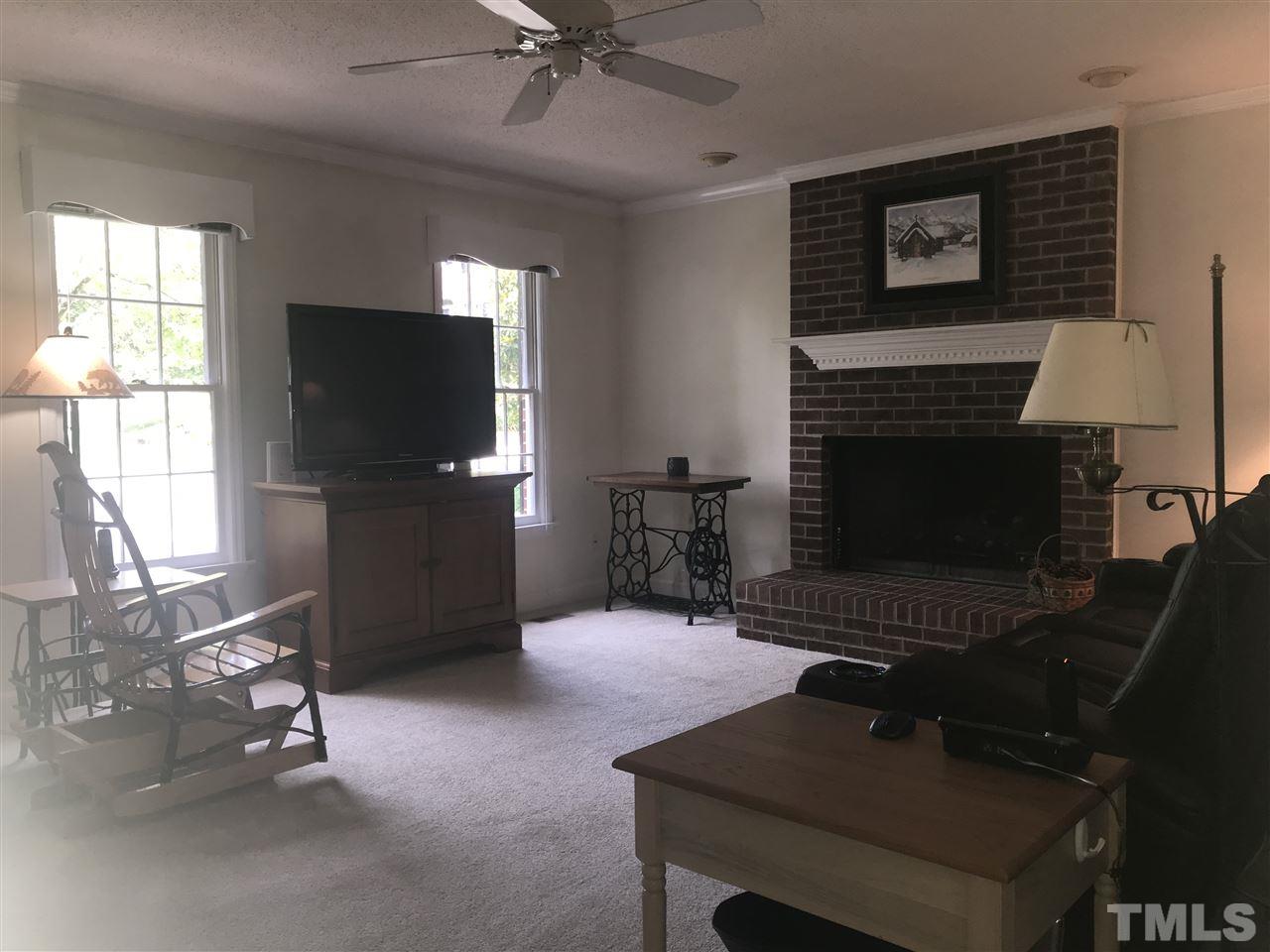 1500 Pecore Place Raleigh, NC 27615 - Photo 4 of 25 a living room with furniture a fireplace and a flat screen tv