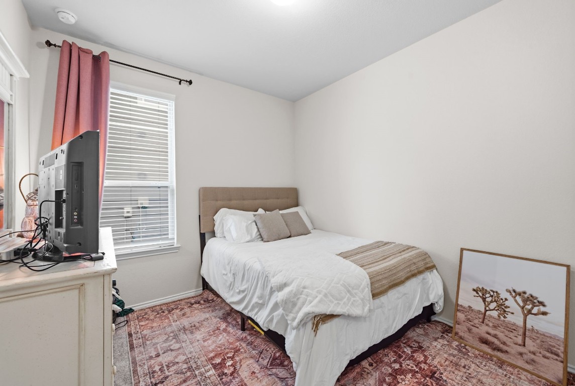 4041 Timber Sapp Drive Conroe, TX 77304 - Photo 11 of 14 a bedroom with a large bed and a flat tv screen on a dresser