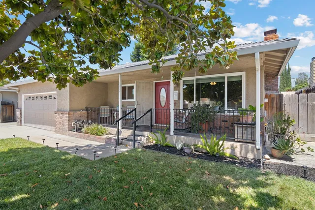 a view of a house with backyard sitting area and garden