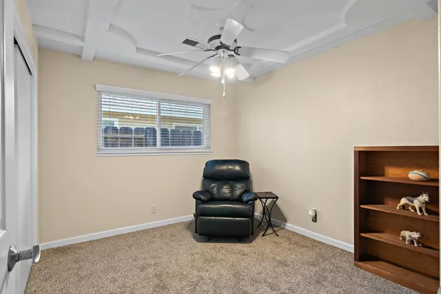 a view of an empty room with a chandelier fan