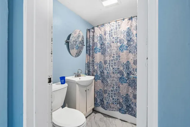 a white toilet sitting next to a shower curtain