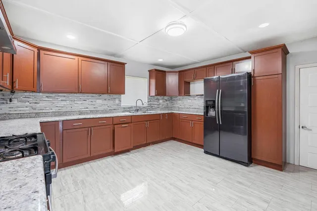 a kitchen with stainless steel appliances granite countertop a refrigerator and a sink