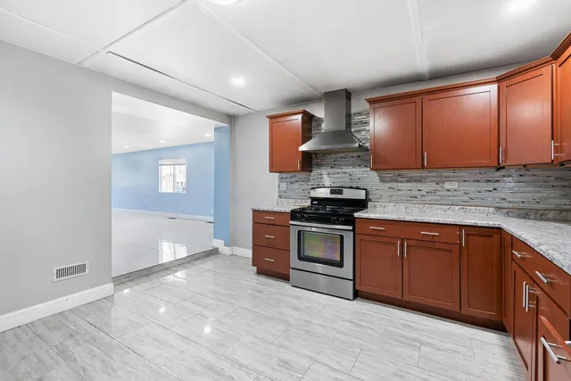 a kitchen with granite countertop a stove top oven sink and cabinets