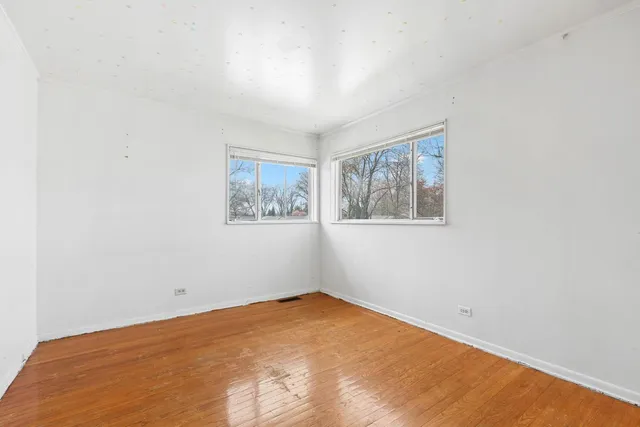 a view of empty room with wooden floor