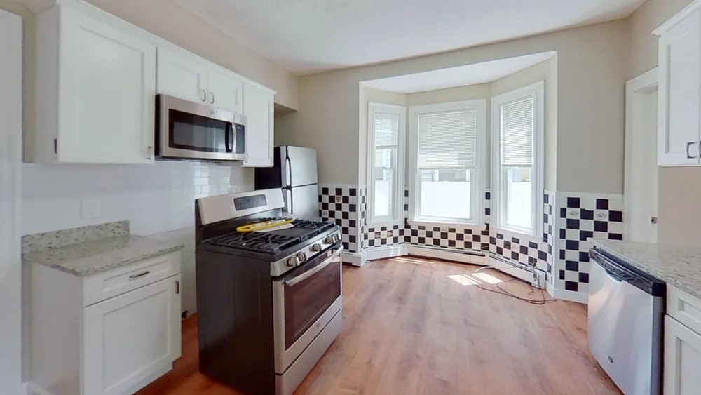 121 George Street, Unit 1 Boston, MA 02119 - Photo 1 of 7 a kitchen with a stove a sink and a refrigerator