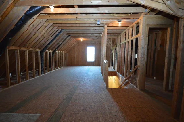 a view of a hallway with wooden floor and windows