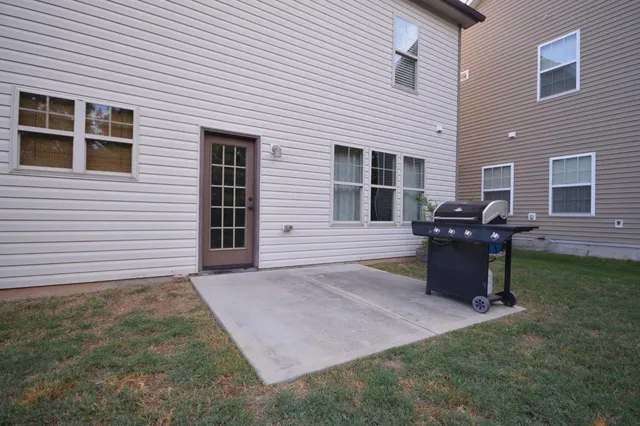 a view of a backyard with plants and barbeque grill