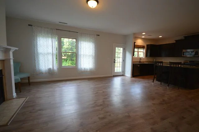 an open kitchen with kitchen island wooden floors and stainless steel appliances