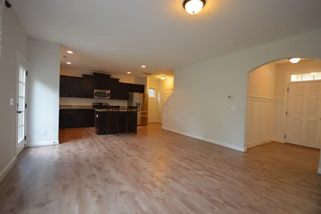 a view of kitchen with kitchen island wooden floor appliances and cabinets