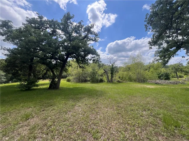 an aerial view of residential house with outdoor space and trees all around